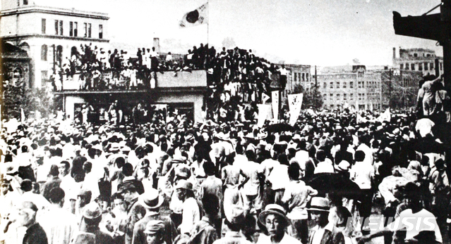 [서울=뉴시스]1945년 8월 16일 오후 조선영화사 최희연 사진기자가 서울역 귀빈실 2층 옥상에 올라가서 찍은 사진. 군중들이 태극기를 들고 건물에 올라가 해방의 기쁨을 만끽하는 모습이 인상적이다. 이 사진은 <국제보도> 창간호에 ‘해방의 날’이란 제목으로 게재됐다. (사진=미디어한국학 제공) 2020.01.12. photo@newsis.com