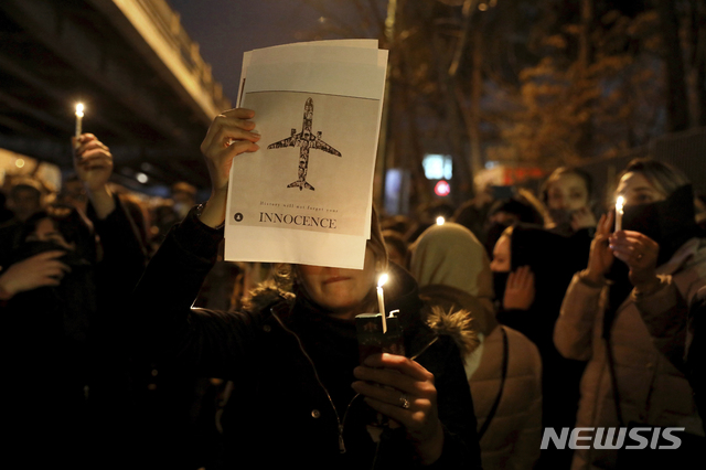People gather for a candlelight vigil to remember the victims of the Ukraine plane crash, at the gate of Amri Kabir University that some of the victims of the crash were former students of, in Tehran, Iran, Saturday, Jan. 11, 2020. Iran on Saturday, Jan. 11, acknowledged that its armed forces "unintentionally" shot down the Ukrainian jetliner that crashed earlier this week, killing all 176 aboard, after the government had repeatedly denied Western accusations that it was responsible. (AP Photo/Ebrahim Noroozi)