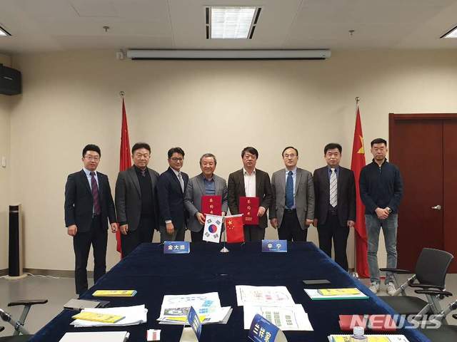 [제주=뉴시스] 국제전기자동차엑스포와 인민일보 자동차신문그룹이 전기차 산업발전을 위한 MOU를 체결한후 관계자들이 기념촬영을 하고 있다.(사진= 국제전기자동차엑스포 제공)