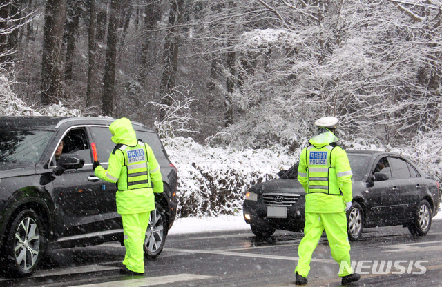 [제주=뉴시스]강경태 기자 = 한라산에 대설주의보가 내려진 지난달 14일 오전 제주시 첨단과학기술단지 입구 교차로에서 자치경찰이 월동 장구를 하지 않은 차량에게 우회도로를 이용해달라며 당부하고 있다. 2020.01.14. ktk2807@newsis.com