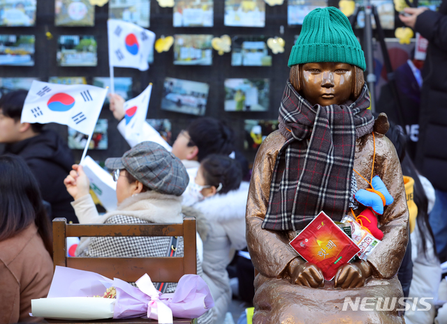 [서울=뉴시스]김근현 기자 = 시민들이 지난달 15일 오후 1422차 일본군성노예제 문제해결을 위한 정기 수요시위에 참석해 태극기를 흔들고 있다. 2020.01.15.khkim@newsis.com