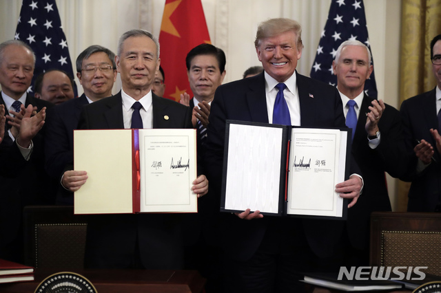 [워싱턴=AP/뉴시스]도널드 트럼프(오른쪽) 미국 대통령과 류허 중국 중앙정치국 위원 겸 부총리가 15일(현지시간) 백악관 집무실에서 미중 1단계 무역 합의안에 서명 후 기념촬영을 하고 있다. 합의안에는 중국이 앞으로 2년에 걸쳐 2000억 달러(약 231조 6000억 원)어치의 미국산 상품을 추가로 구매한다는 내용 등이 담겼다. 2020.01.16. 