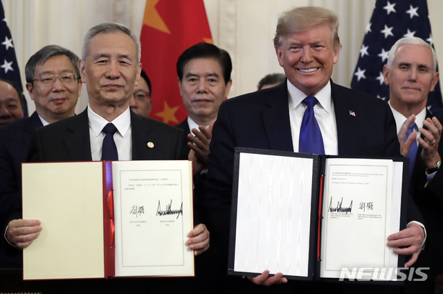[워싱턴=AP/뉴시스]도널드 트럼프(오른쪽) 미국 대통령과 류허 중국 부총리가 지난 15일 백악관 집무실에서 미중 1단계 무역 합의안에 서명 후 기념촬영을 하는 모습. 2020.01.22.