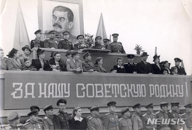 [서울=뉴시스] 1945년 7월 소련군 극동 최고사령관에 부임한 알렉산드르 바실리예프스키 원수가 일본 관동군과의 결전을 앞두고 극동군 총사령부가 있던 하바롭스크에서 군 장병과 가족들 앞에서 연설하고 있다. 한반도 진주 이후 미소공동위원회 소련 측 수석대표와 북한주재 초대 소련대사를 역임하는 티렌티 스티코프 연해주군관구 군사위원(상장)이 서 있다. 단상에 ‘우리 소비에트 조국을 위하여!’란 현수막이 걸려 있다. (사진=미디어한국학 제공) 2020.01.19. photo@newsis.com