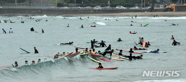  [부산=뉴시스] 하경민 기자 = 해양레저스포츠의 도시인 부산의 대표 해수욕장 중 하나인 송정해수욕장에서 17일 전국에서 몰려든 서퍼들이 ‘서핑'을 즐기고 있다. 2020.01.17. photo@newsis.com
