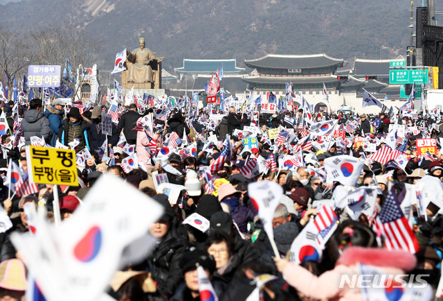 [서울=뉴시스]이윤청 기자 = 18일 서울 종로구 교보빌딩 앞에서 문재인하야범국민투쟁본부 주최로 열린 '대한민국 바로세우기 국민대회'에서 참가자들이 태극기와 성조기를 들고 구호를 외치고 있다. 2020.01.18. radiohead@newsis.com
