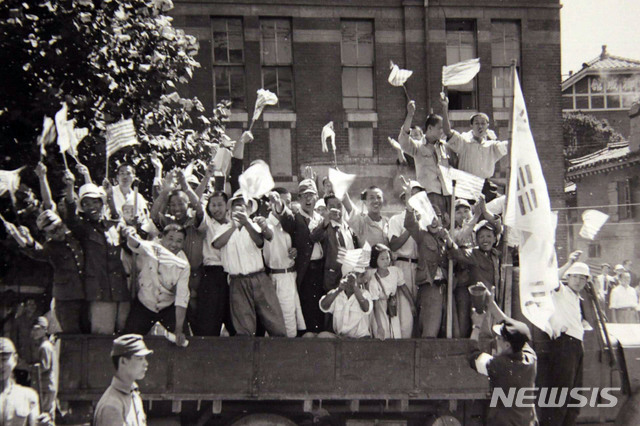 [서울=뉴시스] 1945년 9월 9일 서울에 입성하는 미군을 환영하기 위해 나온 서울 시민들이 트럭에 올라 태극기와 성조기를 흔들고 있다. (사진=미국 국립문서기록청) 2020.01.26. photo@newsis.com
