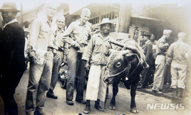 [서울=뉴시스] 1945년 서울에 주둔한 미군들이 시장통에서 물건 구입 후 소달구지를 끌고 가는 한 조선인과 기념촬영을 하고 있다. 이 사진은 뉴시스 '광복 75주년' 연재를 위해 단독 입수하여 최초 공개하는 사진으로 미군 병사가 1945년 10월경에 찍은 사진 중의 하나다. 2020.01.26. photo@newsis.com