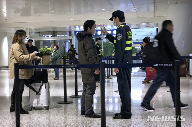 [우한(중 후베이성)=AP/뉴시스] 21일 중국 후베이성 우한시 국제공항에서 한 검역요원이 한 승객의 체온을 체크하고 있다. 우한발 폐렴이 전국 전역으로 확산돼 대유행 공포가 커지고 있다. 2020.01.22 