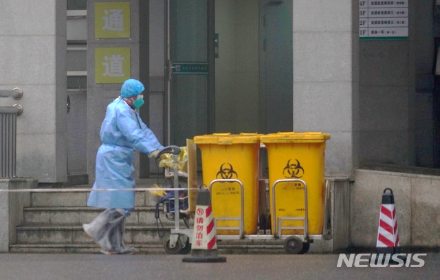 [우한=AP/뉴시스] 22일(현지시간) 신종 코로나바이러스 진원지인 중국 후베이성 우한시의 의료 시설 모습. 감염자를 치료하는 이곳에서 한 직원이 의료 폐기물을 옮기고 있다. 2020.01.24. 