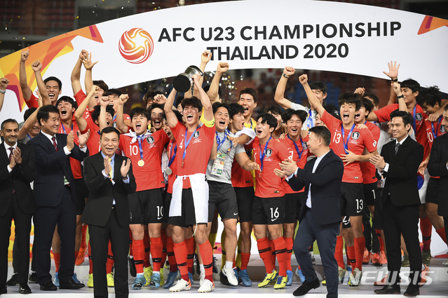 [방콕=AP/뉴시스]대한민국 주장 이상민(가운데)이 26일(현지시간) 태국 방콕의 라자망갈라 경기장에서 막을 내린 아시아축구연맹(AFC) U-23 챔피언십 우승컵을 들고 동료들과 시상대에 올라 환호하고 있다. 김학범 감독이 이끈 대한민국은 0-0 무승부 이후 연장 후반 8분 터진 정태욱의 결승 골로 1-0으로 승리해 이 대회 첫 우승을 차지했다. 2020.01.27. 