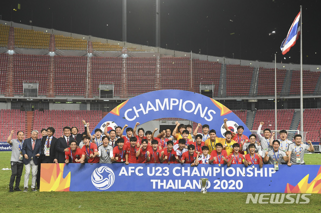 [방콕=AP/뉴시스]대한민국 선수단과 축구협회 관계자들이 26일(현지시간) 태국 방콕의 라자망갈라 경기장에서 막을 내린 아시아축구연맹(AFC) U-23 챔피언십에서 사우디를 꺾고 우승, 트로피를 앞에 놓고 기념촬영을 하고 있다. 김학범 감독이 이끈 대한민국은 연장 후반 8분에 터진 정태욱의 결승 골로 1-0으로 승리해 이 대회 첫 우승을 차지했다. 2020.01.27.