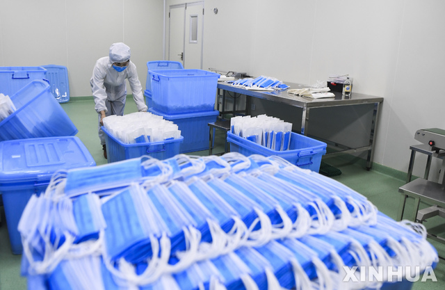 [충칭=신화/뉴시스] 중국 충칭에 있는 의료기 생산공장에서 지난 1월 27일 한 근로자가 마스크 제품을 옮기고 있다.