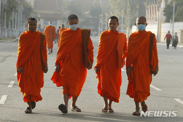 [프놈펜=AP/뉴시스]캄보디아에서도 '우한 폐렴' 환자가 확인된 가운데 1월28일 수도 프놈펜에서 승려들이 마스크를 쓰고 거리를 걷고 있다. 2020.01.28.