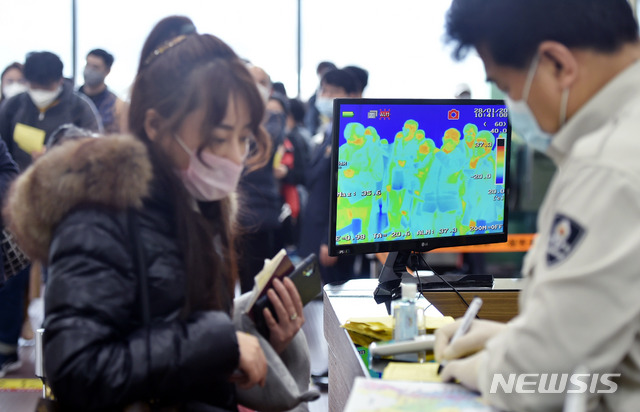 [대구=뉴시스] 이무열 기자 = 질병관리본부가 중국 전역 입국자에 대해 전수검사와 건강 상태 질문서 제출을 의무화한 28일 오전 대구국제공항 국제선 입국장에서 마스크를 쓴 상하이발(發) 비행기 탑승객들이 체온 감지 열화상카메라 검역대를 통과하고 있다. 2020.01.28.lmy@newsis.com