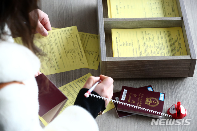 [인천공항=뉴시스]홍효식 기자 = 중국 상해발 입국자들이 28일 인천국제공항에서 건강상태 질문서를 작성하고 있다. 보건당국은 이날부터 신종 코로나바이러스 감염증 확산을 막고자 중국에서 들어오는 모든 입국자의 '건강상태 질문서' 제출을 의무화했다. 2020.01.28. yesphoto@newsis.com