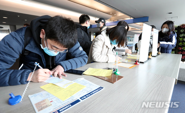 [인천공항=뉴시스]홍효식 기자 = 지난 1월 인천국제공항 1터미널 입국장에 입국한 승객들이 검역소에 제출할 건강상태질문서 등을 작성하고 있다. 2020.03.16. photo@newsis.com