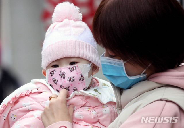 [서울=뉴시스]김병문 기자 = 신종 코로나바이러스 감염증(우한 폐렴)이 확산 중인 28일 오후 서울 중구 명동 거리에서 관광객이 자녀에게 마스크를 씌워주고 있다. 2020.01.28.&nbsp; dadazon@newsis.com