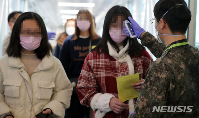 [부산=뉴시스] 하경민 기자 = '우한 폐렴'(신종 코로나바이러스 감염증) 확산 우려가 제기되고 있는 28일 부산 강서구 김해국제공항 국제선 입국장 게이트에서 중국발 항공기를 타고 온 승객들을 상대로 체온 측정이 진행되고 있다. 2020.01.28. yulnetphoto@newsis.com