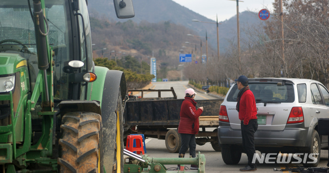 [아산=뉴시스]이종익 기자 = 충남 아산 주민들이 29일 오후 정부가 중국 우한에서 국내로 이송하는 교민과 유학생을 2주간 임시 수용할 것으로 검토중인 아산의 경찰인재개발원 출입로를 트랙터 등을 동원해 차량 출입을 막고 있다. 2020.01.29. 007news@newsis.com 