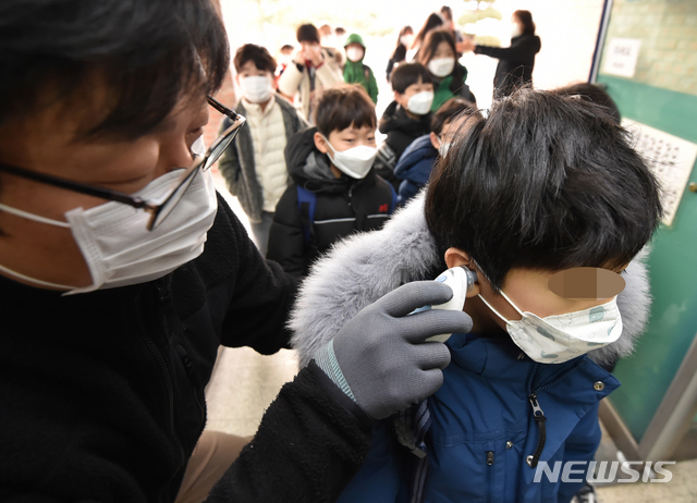 [수원=뉴시스] 김종택 기자 = 신종 코로나바이러스 감염증(우한 폐렴) 확산 우려가 커지는 가운데 29일 오전 경기 수원시 한 초등학교에서 호흡기 질병 예방을 위해 선생님이 학생들을 대상으로 체온 측정을 하고 있다. 2020.01.29.semail3778@naver.com