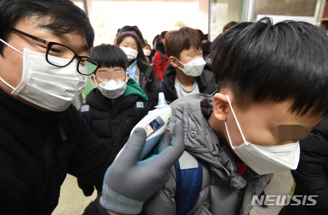 [수원=뉴시스] 김종택 기자 = 신종 코로나바이러스 감염증(우한 폐렴) 확산 우려가 커지는 가운데 29일 오전 경기 수원시 한 초등학교에서 호흡기 질병 예방을 위해 선생님이 학생들을 대상으로 체온 측정을 하고 있다.2020.01.29.semail3778@naver.com