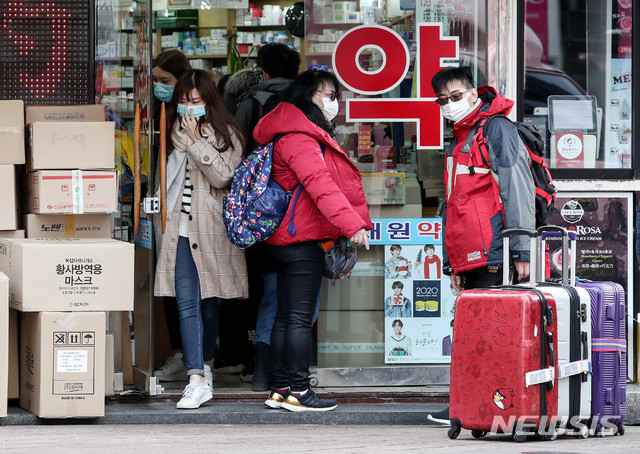 [서울=뉴시스]김병문 기자 = 우한 폐렴(신종 코로나바이러스 감염증)이 확산 중인 29일 오후 서울 중구 명동의 한 약국에서 관광객들이 마스크를 구매하기 위해 줄을 서 있다. 2020.01.29. dadazon@newsis.com