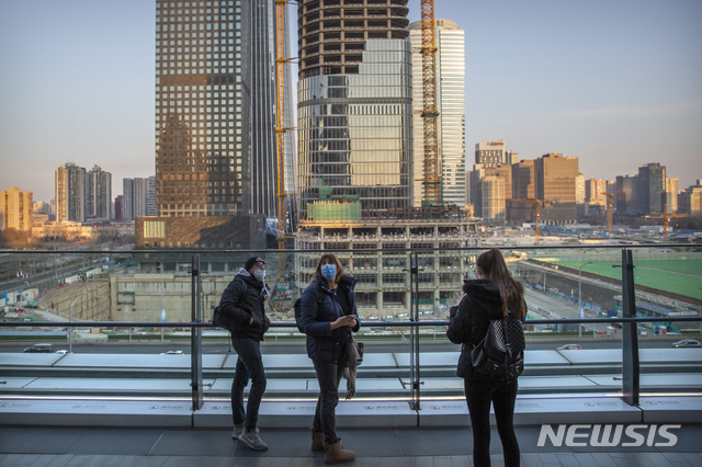 [베이징=AP/뉴시스] 중국 베이징의 한 쇼핑몰 발코니에서 지난 29일 관광객들이 마스크를 쓴 채 주변을 구경하고 있다. 2020.01.30.