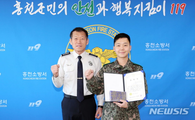 육군 3기갑여단 서무원 상사가 홍천소방서장(남궁규)에게 표창을 수여받고 기념사진 촬영을 하고 있다.