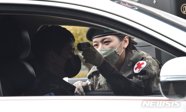 [화성=뉴시스] 김종택 기자 = 30일 오후 경기 화성시 매송면 제51사단 위병소에서 여군이 우한폐렴(신종 코로나바이러스 감염증) 예방을 위해 출입자들의 체온을 측정하고 있다.육군은 부대 출입 인원의 체온을 측정하고 방역을 실시 하는 등 신종 코로나바이러스 감염증 확산 방지를 위한 예방 조치를 적극 시행하고 있다. 2020.01.30.semail3778@naver.com