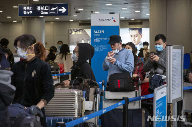 [베이징=AP/뉴시스] 신종 코로나바이러스 감염증(우한 폐렴)이 확산하는 가운데 30일(현지시간) 중국 베이징 서우두 국제공항에서 미국 로스앤젤레스행 비행기를 타려는 승객들이 마스크를 끼고 대기하고 있다. 2020.01.31. 