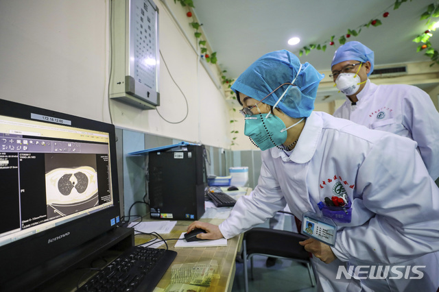 [우한= AP/뉴시스]30일(현지시간) 신종 코로나 바이러스 감염증(우한 폐렴) 진원지인 중국 후베이성 우한시의 한 병원에서 의사들이 환자의 CT 검사 결과를 보고 있다. 2020.01.30. 
