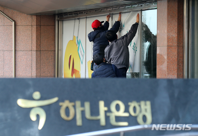 [서울=뉴시스]전신 기자 = 하나은행이 3일부터 브랜드 명칭을 KEB하나은행에서 '하나은행'으로 변경하고 새로운 10년을 준비하는 'NEW 하나은행'으로 새롭게 출발한다고 밝혔다. 이날 서울 중구 하나은행에서 관계자들이 새 래핑광고를 부착하고 있다. 2020.02.03.&nbsp; photo1006@newsis.com