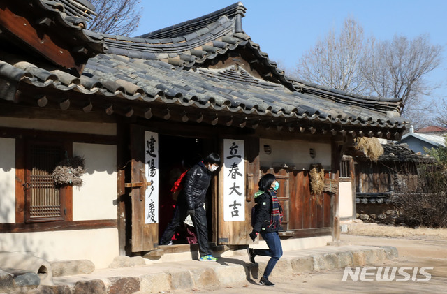 [서울=뉴시스]박미소 기자 = 신종 코로나 바이러스 감염증(우한폐렴)의 여파로 마스크를 쓴 외국인 관광객들이 3일 오후 서울 종로구 경복궁 국립민속박물관 오촌댁 대문에 붙여진 '입춘방' 옆을 지나고 있다. 2020.02.03.  misocamera@newsis.com