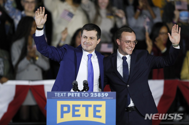 [디모인=AP/뉴시스]미국 민주당 대선 예비후보인 피터 부티지지 전 인디애나 사우스벤드시장(왼쪽)이 지난 3일 아이오와 디모인에서 열린 민주당 코커스에서 자신의 배우자와 연단에 올라 손을 흔들고 있다. 4일(현지시간) CNN 실시간 개표 결과에 따르면 부티지지 전 시장은 62% 개표 기준 26.9%를 득표해 1위를 달리고 있다. 2020.02.05. 