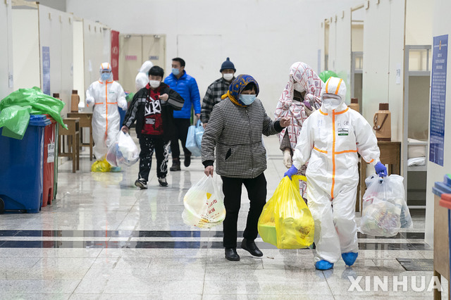 [우한=신화/뉴시스]5일(현지시간) 중국 후베이성 우한의 한 전시장을 개조한 임시병원에 신종 코로나바이러스 감염증(우한 폐렴) 환자들이 의료진의 도움으로 입원하고 있다. 현지 관계자는 우한시에서 전시장을 개조한, 1600병상 규모의 첫 임시 병원이 신종 코로나 환자를 받기 시작했다고 전했다. 2020.02.06. 