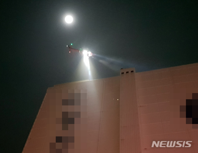 [부산=뉴시스] 6일 오후 10시 47분께 부산 서구 암남동의 한 냉동창고에서 원인이 밝혀지지 않은 불이 나자 소방헬기가 옥상으로 대피한 외국인 노동자 등 4명을 구조하고 있다. (사진=부산소방본부 제공)photo@newsis.com 