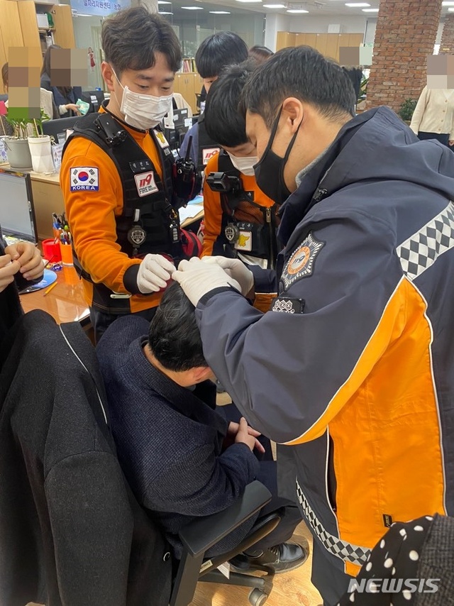 [울산=뉴시스] 구미현 기자 = 7일 오전 울산시 중구청 1층 주민생활지원과에서 60대 민원인으로부터 담당 계장이 폭행을 당하는 사건이 발생했다. 폭행당한 공무원 C(57)씨가 출동한 구급대원에게 머리 상처를 응급 처치받고 있다. 2020.02.07. (사진=울산시 중구 제공) photo@newsis.com