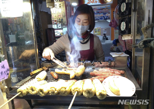 [타이베이=AP/뉴시스]6일(현지시간) 대만 타이베이의 한 야시장에서 마스크를 쓴 한 상인이 음식을 만들고 있다. 2020.02.07. 