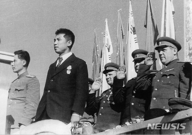 [서울=뉴시스] 1945년 10월 14일 모란봉 아래 평양공설운동장에서 열린 환영대회 주석단에 서 있는 김일성. 왼쪽은 통역으로 활동한 강(姜)미하일 소좌이고, 맨 오른쪽이 레베데프 정치사령관이다. (사진=미디어한국학 제공) 2020.02.09. photo@newsis.com