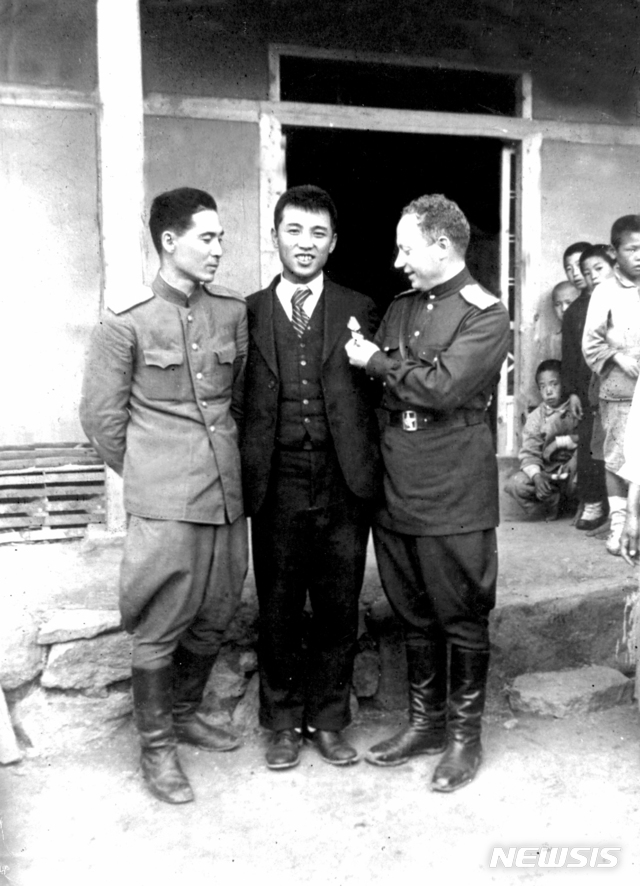 [서울=뉴시스] 1945년 10월 14일 평양공설운동장에서 열린 환영대회를 마치고 고향 집을 방문한 김일성이 동행한 메크레르 소련 25군 정치담당관(오른쪽), 통역관 강(姜)미하일 소좌와 기념 촬영을 하고 있다. (사진=미디어한국학 제공) 2020.02.09. photo@newsis.com