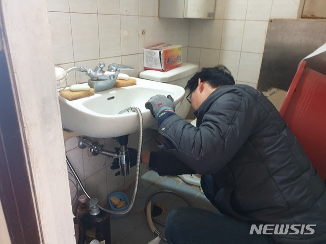 [울산=뉴시스] 주택을 방문해 세면대 배관을 수리하고 있는 울산 남구 OK생활민원기동대. (사진=울산 남구 제공) photo@newsis.com