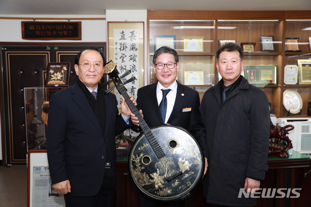 [영동=뉴시스] 인진연 기자 = 전국의 명승지에서 국악사랑 운동을 펼쳐온 '풍류애'가 중국 청대의 '백자무예도 비파'를 충북 영동군에 기증한 뒤 박세복 영동군수와 기념 촬영하고 있다. (사진=영동군 제공) 2020.02.11photo@newsis.com