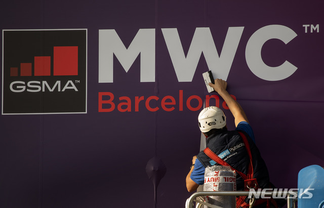 [바르셀로나=AP/뉴시스] 11일(현지시간) 모바일 월드 콩그레스(MWC)가 열릴 예정인 스페인 바르셀로나에서 한 노동자가 MWC 포스터를 수정하고 있다. 이날 페이스북과 인텔도 신종 코로나바이러스 감염증(우한 폐렴)을 우려해 MWC에 참여하지 않겠다고 밝혔다. 2020.02.12.