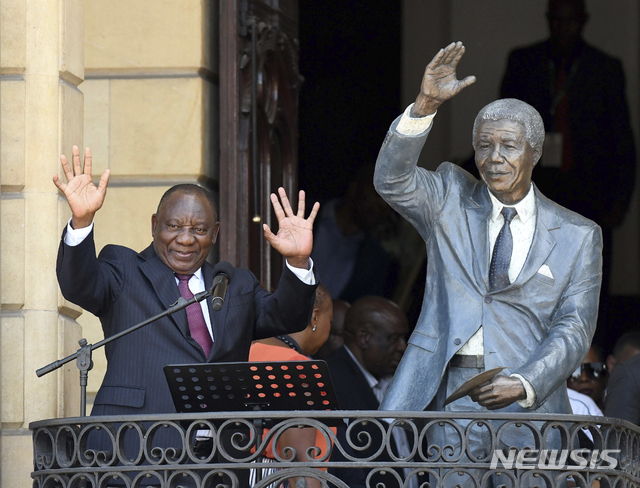 [케이프타운=AP/뉴시스]시릴 라마포사 남아공 대통령(왼쪽)이 지난달 11일(현지시간) 남아공 케이프타운 시청 발코니 넬슨 만델라 동상 옆에서 지지자들에게 손을 흔들고 있다.2020.03.16
