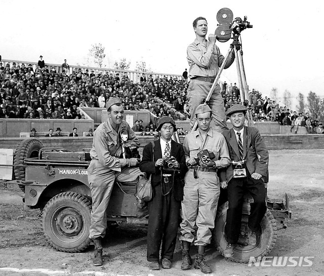 [서울=뉴시스] 1945년 12월 19월 서울운동장에서 열린 ‘대한민국임시정부 개선전국환영대회’를 취재하고 있는 촬영가와 사진기자들. 오른쪽부터 임석제(林奭濟) 서울타임스 사진기자, 오브라이언(Don O" Brien) 미군 종군기자, 최희연(崔禧淵) 조선영화사 사진기자(후에 경향신문 사진부장)로 추정된다. (사진=돈 오브라이언 flickr) 2020.02.09. (* 위 사진은 재배포, 재판매, DB 및 활용을 금지합니다.) photo@newsis.com