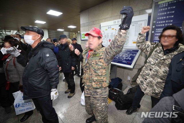 [서울=뉴시스]김선웅 기자 = 5.18 북한군 개입설을 주장한 지만원 씨에 대한 1심 징역 2년이 선고된 13일 오후 서울 서초구 서울중앙지법에서 지 씨 측 지지자들이 무죄를 주장하며 방청에 참석한 5월단체 관계자들을 향해 구호를 외치고 있다. 2020.02.13. mangusta@newsis.com