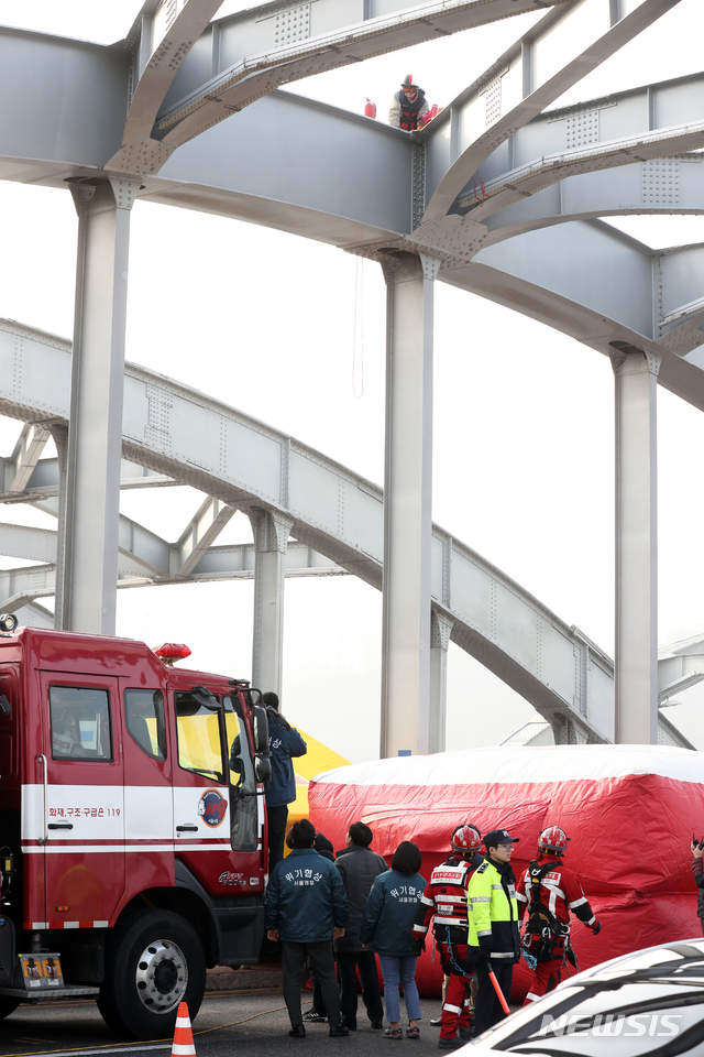 [서울=뉴시스]이윤청 기자 = 한 남성이 14일 오전 한강대교 아치 위에서 ‘세상은 달라졌다. 남성 관련 법과 제도 다 바꾸자’라는 문구가 적힌 현수막을 내걸고 농성 중인 가운데 경찰들과 대화하고 있다. 2020.02.14. radiohead@newsis.com
