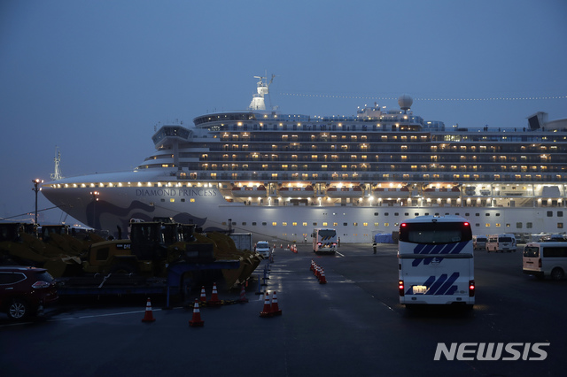  [요코하마=AP/뉴시스] 16일 밤 요코하마항 정박의 크루즈 선 다이아몬드 프린세스호 객실 곳곳에 불이 환하게 켜진 가운데 버스가 앞에 도착하고 있다. 미 국무부는 이날 중으로 미국인 탑승자들을 하선 귀국시킬 방침이다. 크루즈선은 4일부터 코로나 19 감염확산 위험으로 강제 정박된 상황이며 하선한 미국인들은 전세기 귀국 뒤 14일간 의무 격리 조치된다. 2020. 2. 16.&nbsp;&nbsp; 