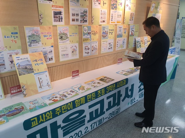 [서울=뉴시스]김정현 기자=서울시교육청은 17일 초등학교 3학년 사회과 수업에 사용될 각 자치구별 마을교과서 25종을 제작했다고 밝혔다. 서울시교육청 관계자가 전시된 마을교과서를 살펴보고 있다. 2020.02.17.ddobagi@newsis.com